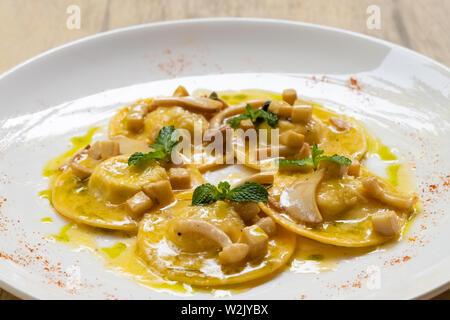 Von Ravioli mit Ricotta und Parmesan, Spinat, Pilzen isoliert auf eine weiße Platte, professionell ausgebildeten Küchenchef im Restaurant natürliche zurück Stockfoto