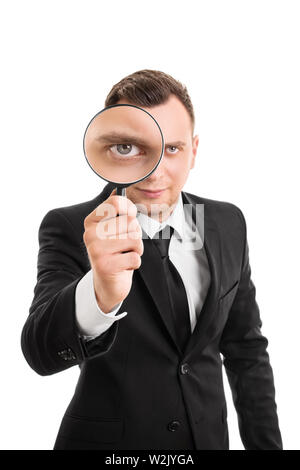 Das Porträt einer jungen Geschäftsmann durch ein Vergrößerungsglas, auf weißem Hintergrund. Stockfoto