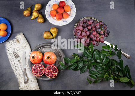 Bodegon der frischen Früchte. Granatäpfel, schwarzen Trauben, Aprikosen, Birnen und Äpfel. Stockfoto