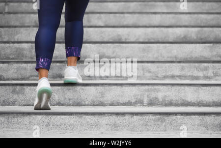 Läuferin Athlet eine Treppe klettern. Frau ausgeführt wird, führen Sie die Schritte auf der Treppe in der Stadt. Tun cardio sport training. Übung outsi Stockfoto