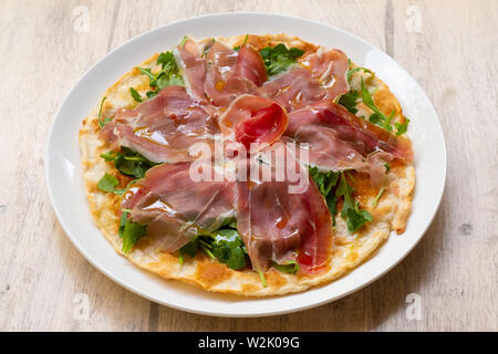 Focaccia di Recco traditionelle italienische Gericht aus der Region Ligurien, Genua, gefüllt mit stracchino Käse, Parmaschinken DOP, Rucola und Olivenöl Stockfoto