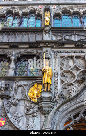 Vergoldete Statue von Krieger in Rüstung, Schwert und Schild auf der Fassade des XII. Jahrhunderts Römisch-katholische Basilika des Heiligen Blutes in Brügge, Belgien. Stockfoto