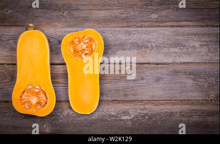 Kürbis in Scheiben über dem alten Holz Hintergrund mit absichtlichen Vignette Stockfoto