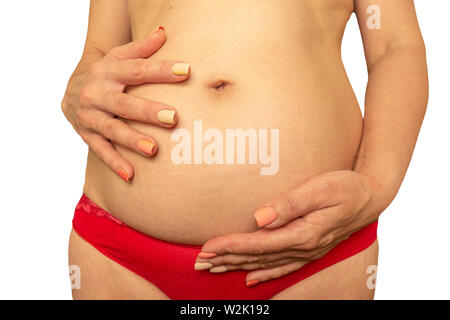 Schwangerschaft nach 40 Jahren Konzept. Ältere schwangere Frau Bauch Schließen Sie herauf Bild auf isolierten Hintergrund. Im Alter die Hände Falten und schlaffe Haut Stockfoto
