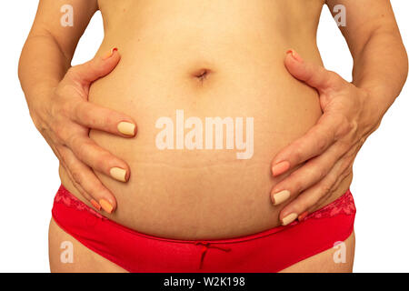 Schwangerschaft nach 40 Jahren Konzept. Ältere schwangere Frau Bauch Schließen Sie herauf Bild auf isolierten Hintergrund. Im Alter die Hände Falten und schlaffe Haut Stockfoto
