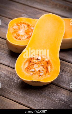Kürbis in Scheiben über dem alten Holz Hintergrund mit absichtlichen Vignette Stockfoto