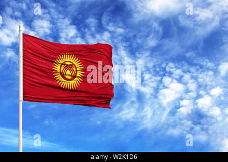 Nationalflagge von Kirgisistan auf einem Fahnenmast vor blauem Himmel Stockfoto