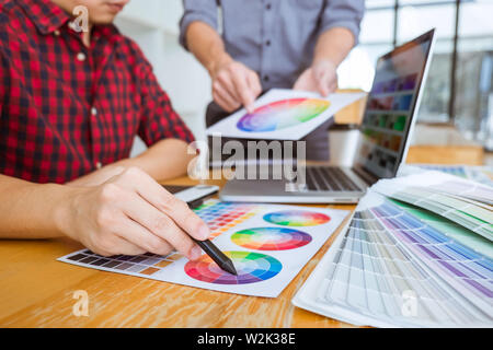 Team von kreativen Grafiker treffen auf Neues Projekt, wählen Sie Auswahl Farbe und Zeichnung auf Grafiktablett mit Arbeit Werkzeuge und Zubehör Stockfoto