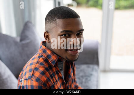 Mann entspannt auf einem Sofa im Wohnzimmer zu Hause Stockfoto