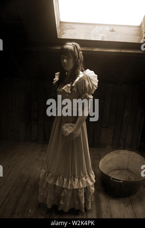 Junge Frau in Vintage-Kleid im Dachgeschoss Stockfoto