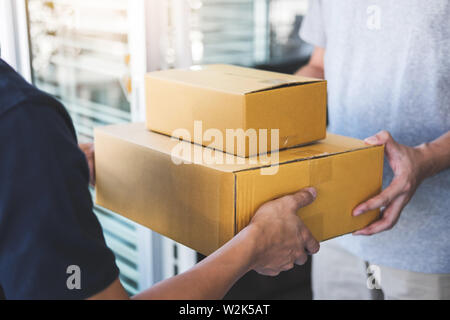 Lieferung mail Mann, Paket, um Empfänger, junge Eigentümer Annahme von Kartonagen Paket von Post Versand, Home Kurier- und Lieferung Servi Stockfoto