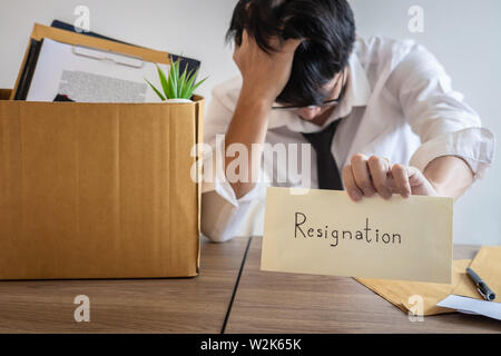 Betonte Geschäftsmann wird Resignation und packen Sachen unternehmen und Dateien in Braun Karton, Änderung und Rücktritt von der Arbeit anhand von quantitativen Simulatio Stockfoto