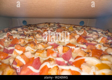 Innerhalb einer Pizza Box. Klassische Pizza in einem Karton. Weitwinkel Blick von oben. Pizza Delivery, Menü. Fast food, knusprigem Teig Stockfoto