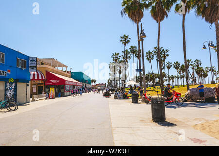 VENICE Beach, Kalifornien, USA - 10. April 2019: Strandpromenade mit Geschäften und Palmen an einem sonnigen Tag in Los Angeles, Kalifornien, USA Stockfoto