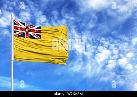 Nationalflagge von Niue auf einem Fahnenmast vor blauem Himmel Stockfoto