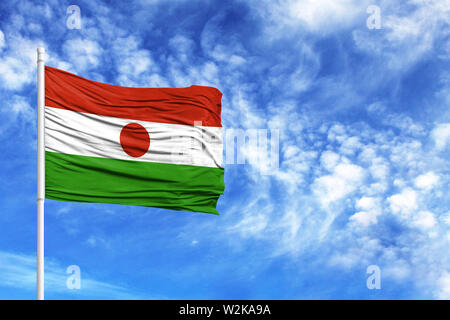 Nationalflagge von Niger an einem Fahnenmast vor blauem Himmel Stockfoto