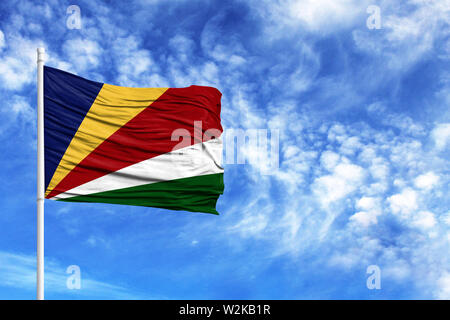 Flagge der Seychellen auf einem Fahnenmast vor blauem Himmel Stockfoto