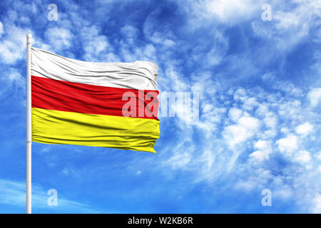 Nationalflagge von Südossetien an einem Fahnenmast vor blauem Himmel Stockfoto