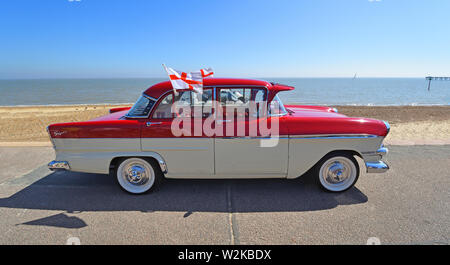Classic Rot und Creme Vauxhall Victor Super Auto geparkt auf Strandpromenade. unter der Flagge von St. George. Stockfoto