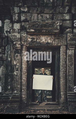 Junger Mann, die leere Plakette in dunklen mystischen Ort Stockfoto
