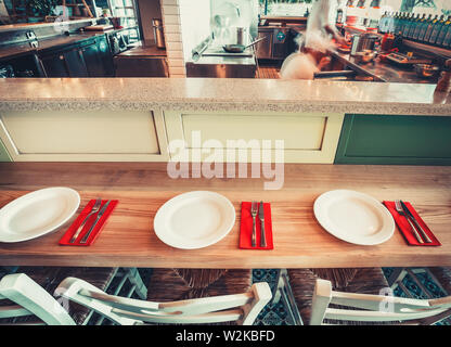 Innenraum der modernen Restaurant mit Tisch, Stühlen und Geschirr Stockfoto