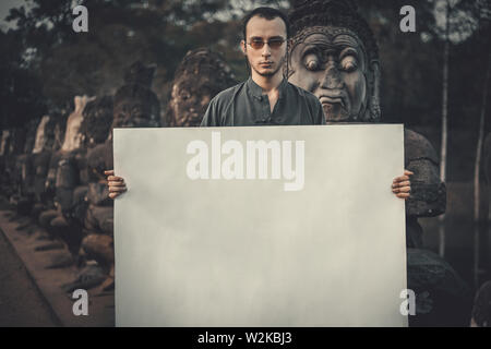 Junger Mann, die leere Plakette in dunklen mystischen Ort Stockfoto