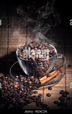 Dampfende Tasse Kaffee, Cinnamon Sticks und einem Kaffee Bohnen Stockfoto