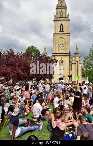 Menschen jeden Alters im Sitzen, im Stehen "Hängende über "im Summer Bristol St Pauls Karneval, Portland Square, Großbritannien Stockfoto