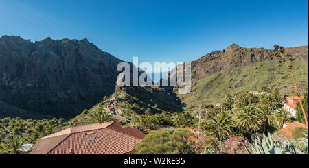 Atemberaubende Landschaft Bergdorf in tiefe Schlucht mit Jungle Wald auf einer paradiesischen Insel. Wunderschöne goldene Stunde des warmen und sonnigen Tag. Reisen Foto, pos Stockfoto
