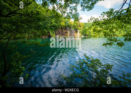 Kaskaden von Reines, frisches Wasser, ausgegossen Braun, bemoosten Felsen in einem azurblauen See im Nationalpark Plitvicer Seen Plitvicer Seen, Kroatien Stockfoto