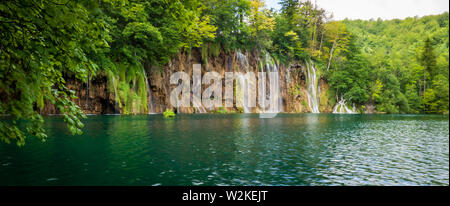 Kaskaden von Reines, frisches Wasser, ausgegossen Braun, bemoosten Felsen in einem azurblauen See im Nationalpark Plitvicer Seen Plitvicer Seen, Kroatien Stockfoto