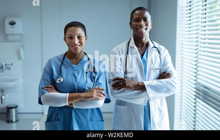 Männliche und weibliche Ärzte lächelnd im Krankenhaus Stockfoto