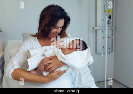 Die Mutter, die ihr neugeborenes Baby Kind nach der Arbeit in der Gemeinde Stockfoto