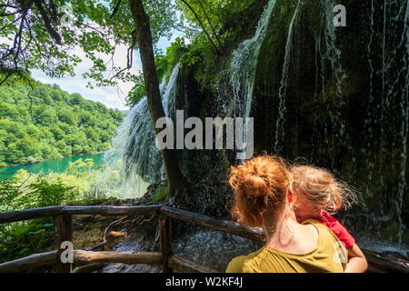 Die Mutter der 3 Jahre alten Mädchen vor einer Felswand, wo Reines, frisches Wasser, hetzen die Kante - Nationalpark Plitvicer Seen in Kroatien Stockfoto