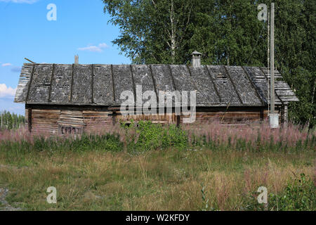 Alte, graue und verwitterte Nebengebäude mit Disrepair Holz Schindeldach an verlassenen Gehöft in Ylöjärvi, Finnland Stockfoto