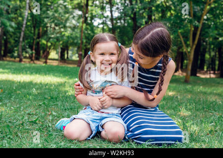 Zwei süße kleine Schwestern Spaß im Park im sonnigen Sommertag Stockfoto