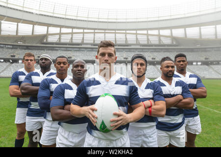 Gruppe von verschiedenen männlichen Rugby Spieler zusammen mit Rugby Ball im Stadion Stockfoto