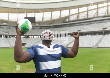 Happy African American Rugbyspieler Jubel mit der Kugel im Stadion Stockfoto