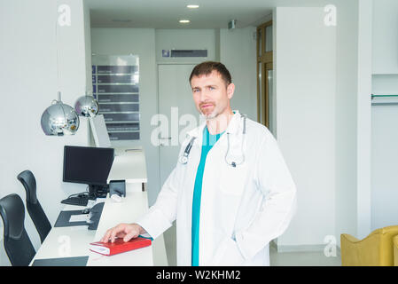 Reife männliche zuversichtlich Doctor's Portrait am Krankenhaus, Rezeption in der Halle des modernen medizinischen Klinik. Gesundheitswesen und mrdicine Konzept Stockfoto
