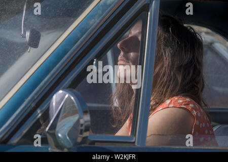 Eine attrrative junge Frau in einem Auto sitzen Stockfoto