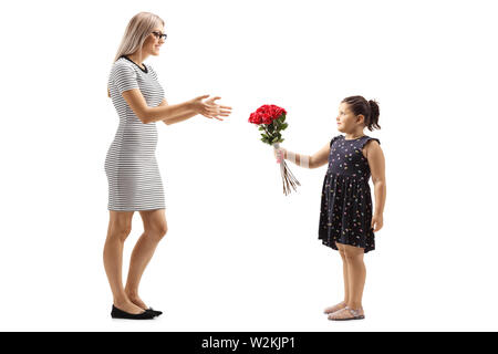 Volle Länge geschossen von einem kleinen Mädchen mit einem Strauß roter Rosen in eine junge Frau auf weißem Hintergrund Stockfoto