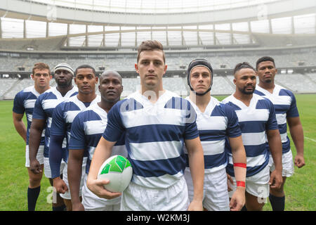 Gruppe von verschiedenen männlichen Rugby Spieler zusammen mit Rugby Ball im Stadion Stockfoto