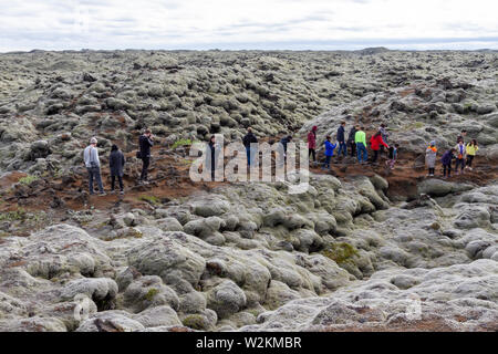 Die Besucher gehen durch Lava aus dem Laki Lava fließt in Woolly fringe Moos bedeckt (racomitrium lanuginosum), Skaftáreldahraun, Island. Stockfoto