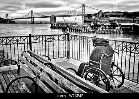 Alte senior real man auf einem Dock in San Francisco, der behindert ist und allein und Obdachlose im Rollstuhl Stockfoto