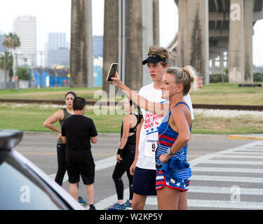 Läuferin nimmt ein smart phone selfie vor Beginn der 2019 Vier für das 4./4 km Fun Run in Corpus Christi, Texas USA. Stockfoto