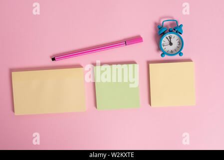 Drei mehrfarbige leer Notizblöcke Wecker Marker farbigen Hintergrund Stockfoto