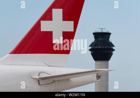 Die heckflosse eines Swissair airliner entlang der Start- und Landebahn vor dem Kontrollturm am Flughafen Manchester rollen. Stockfoto