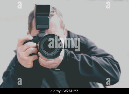 Porträt eines professionellen Fotografen mit einer Kamera in Richtung des Themas hingewiesen Stockfoto