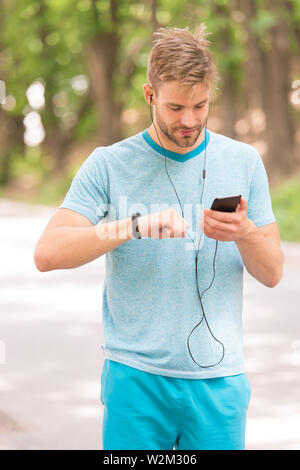 Armband Gadget. Athlet prüfen Fitness tracker Natur Hintergrund. Athleten aus schrittzähler Gadget. Sportler trainieren mit smart Watch. Einrichten fitness Tracker. Fitness Trainer. Nützliche Einstellungen. Stockfoto