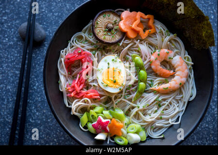 Schüssel japanischer Buchweizen Ramen Nudelsuppe mit bunten toppings Rechtschreibung 2019 in Essig eingelegte Ingwer, gekochtes Ei, Edamame Bohnen, und Garnelen Stockfoto